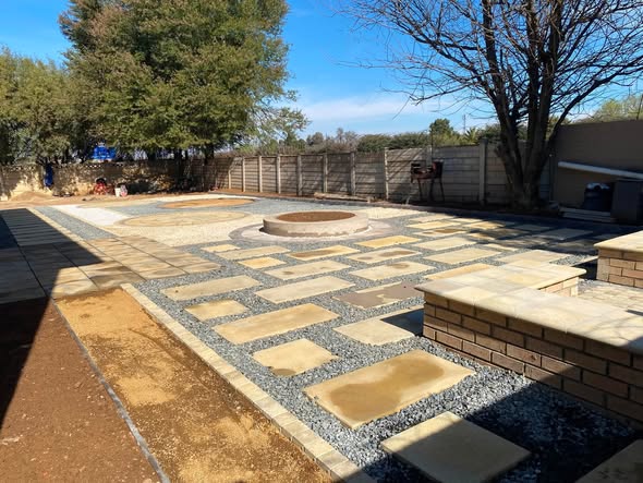 The same courtyard from a wider angle, showing the stepping-stone path and built-in braai corner.