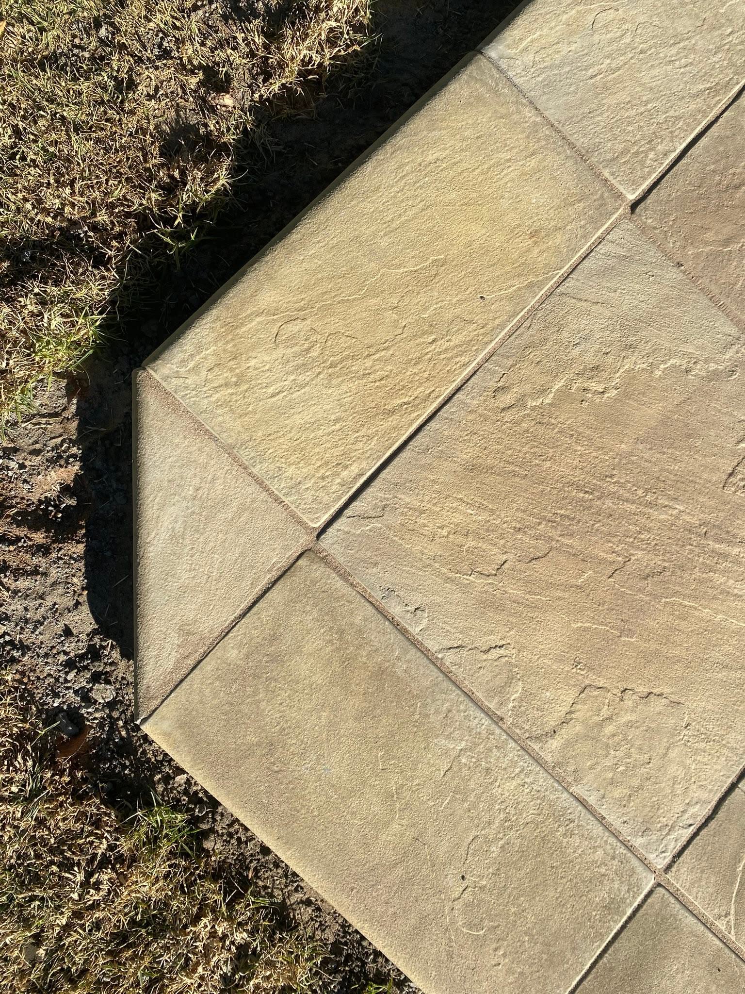 Close-up of textured stone paving cut to fit a garden corner.